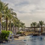 A swimming pool surrounded by palm trees in Bahrain, representing things to pay attention to when renting an apartment in Bahrain